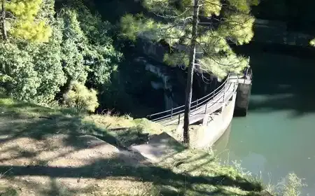 Small Bhalu Dam reservoir surrounded by forest near Ranikhet