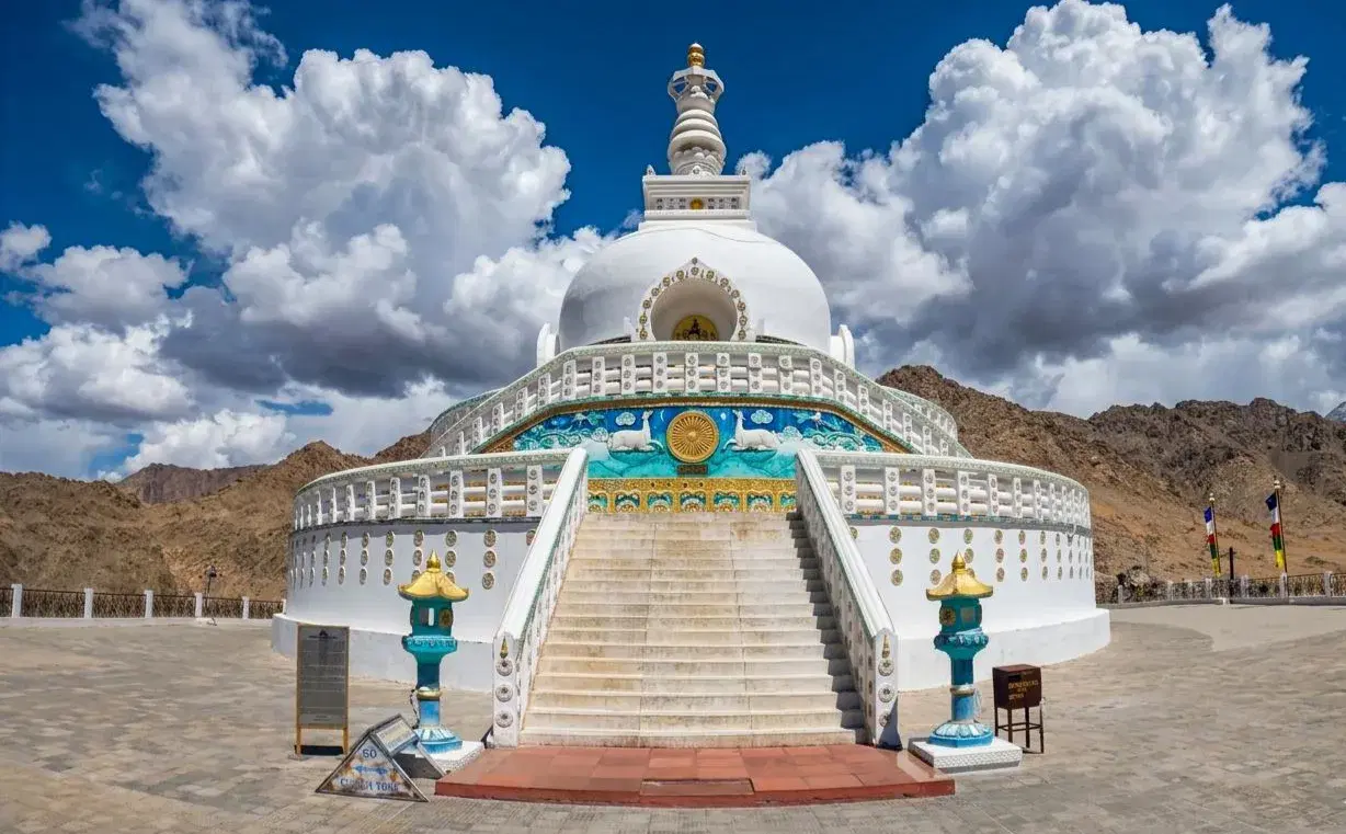 Shanti Stupa's white dome glowing at sunset with panoramic views of Leh Valley, Indus River, and Karakoram range, Ladakh