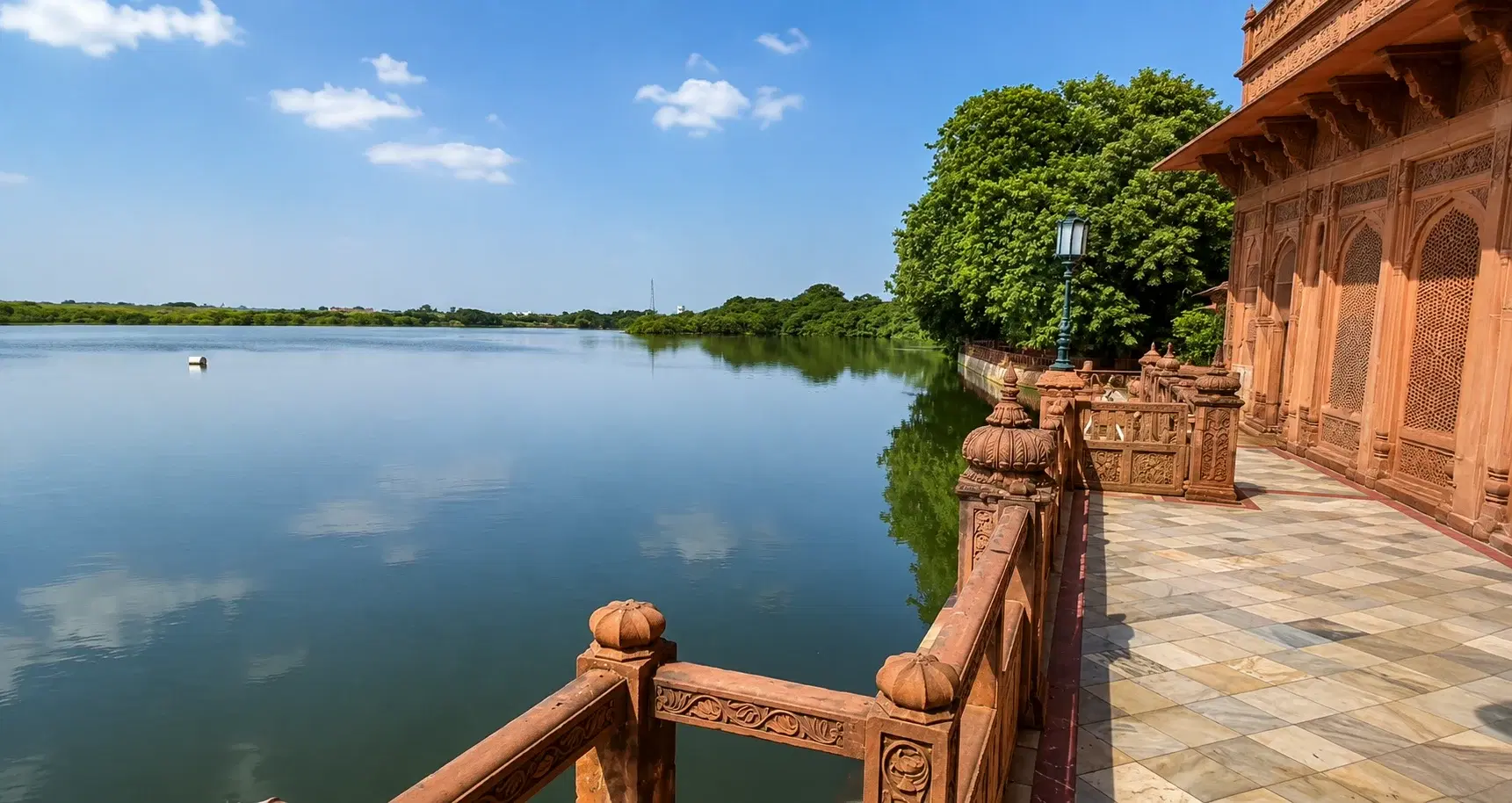 Gajner Palace red sandstone heritage hotel reflected in Gajner Lake with wildlife sanctuary surrounding it, 32 km from Bikaner