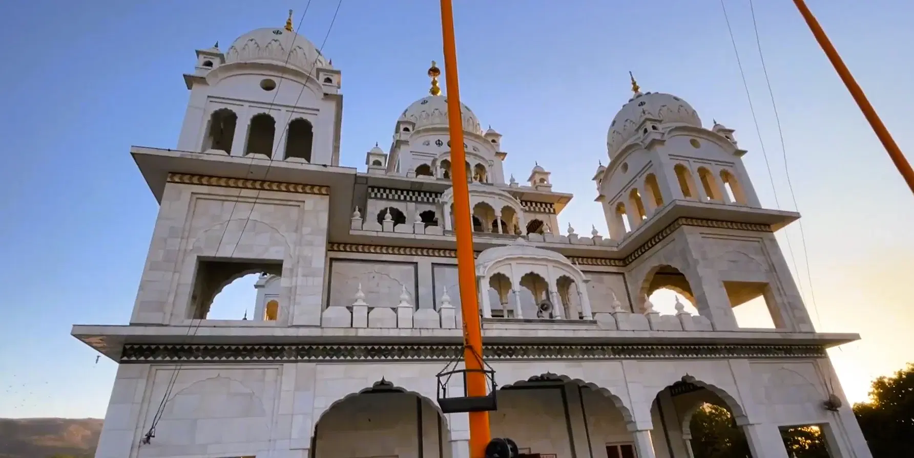 White domed facade and Nishan Sahib flagpole at Gurudwara Singh Sabha in Pushkar