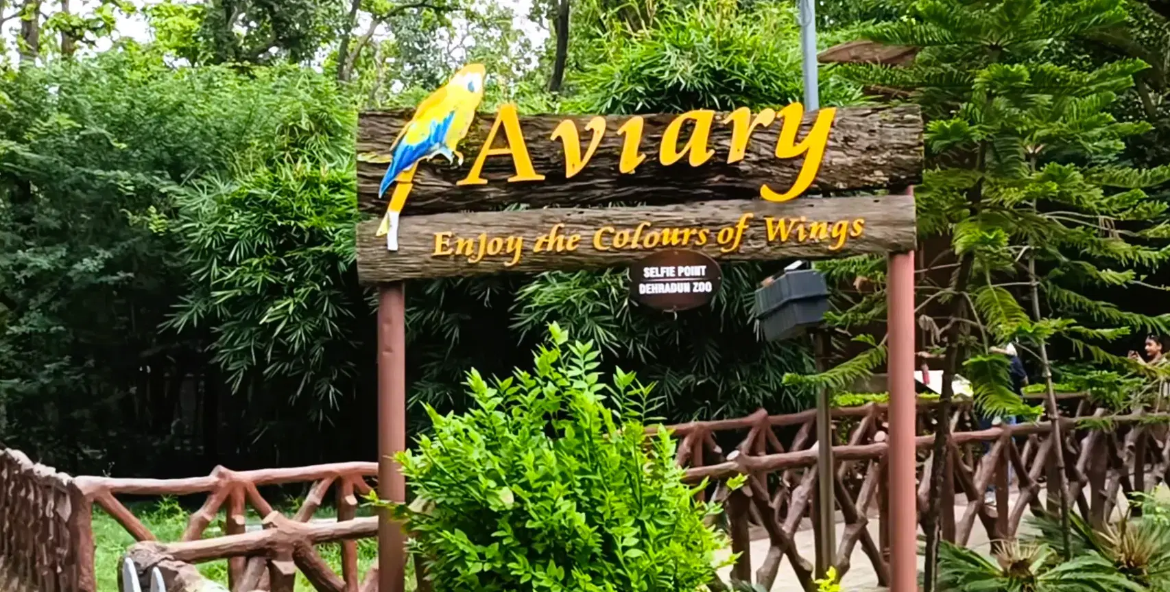 Aviary sign surrounded by greenery inside Dehradun Zoo