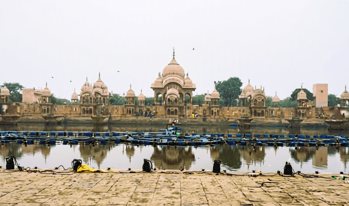 Sacred Kusum Sarovar reservoir with ornate ghats and royal cenotaphs at the base of Govardhan Hill near Vrindavan