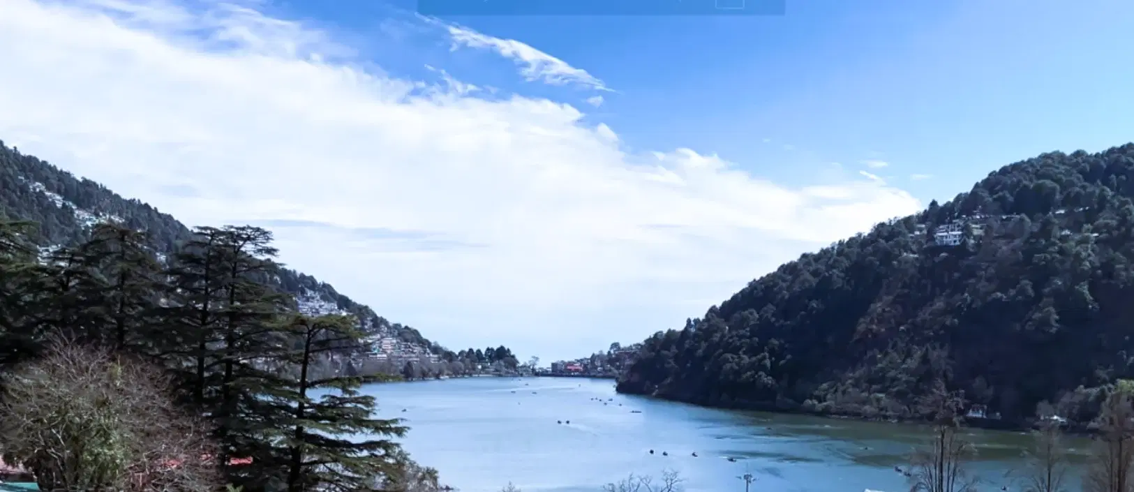 Aerial view of crescent-shaped Naini Lake surrounded by Nainital's forested hills