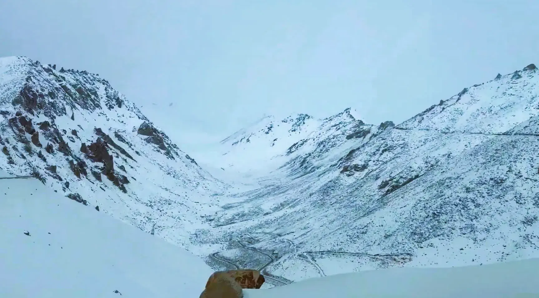 Khardung La Pass at 5,359 m with prayer flags, snow-covered peaks, and the gateway to Nubra Valley from Leh, Ladakh