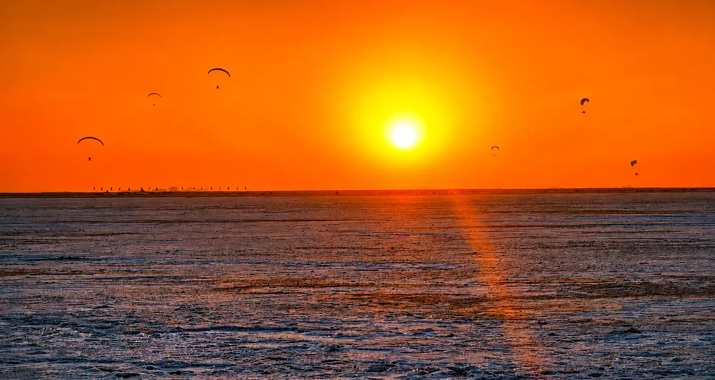 Paragliders above the Great Rann of Kutch at sunset