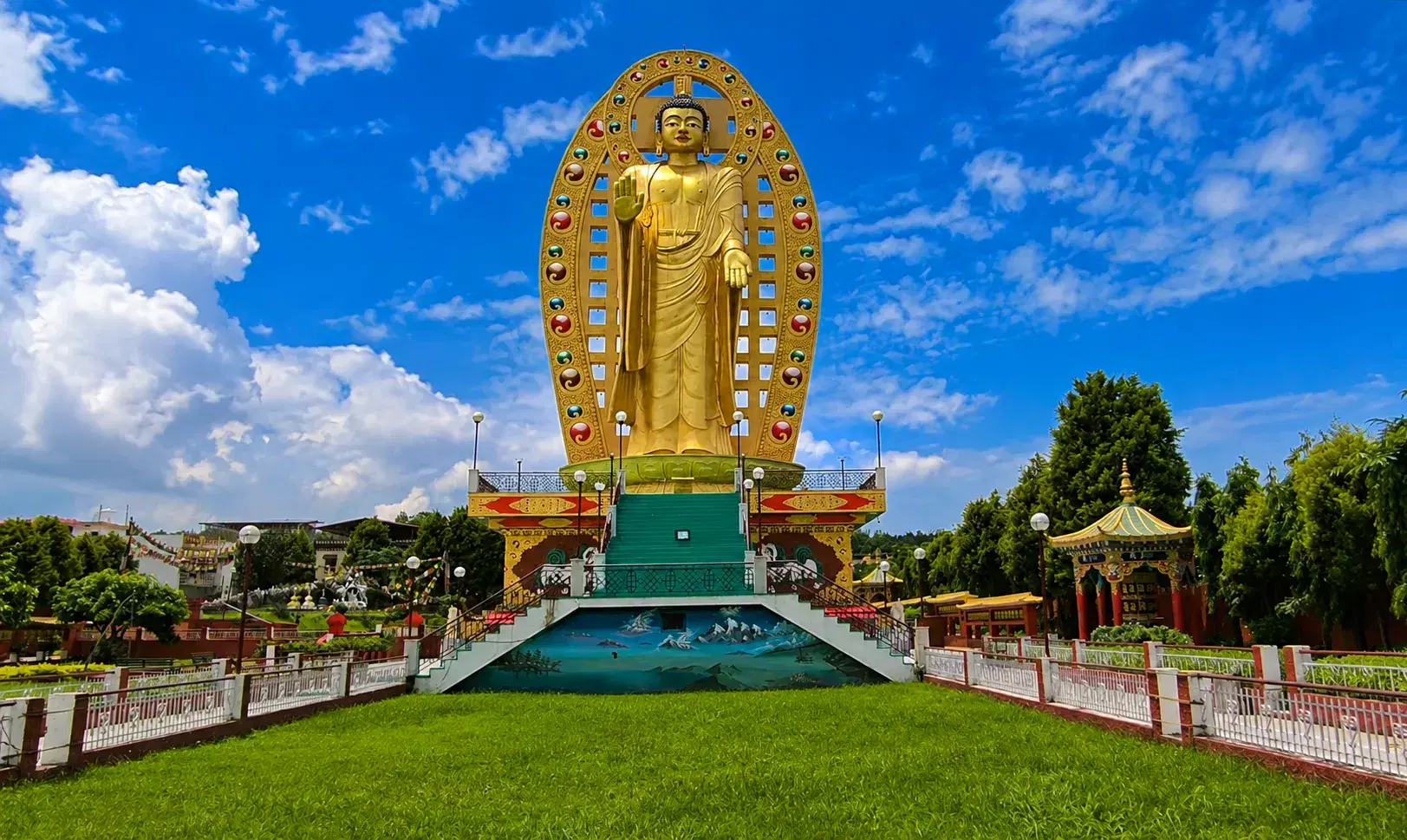 Large golden Buddha statue beneath a blue sky at Mindrolling Monastery in Dehradun